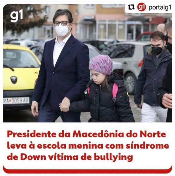 Notícia do G1 mostra foto do presidente dando a mão a uma garota com síndrome de down.